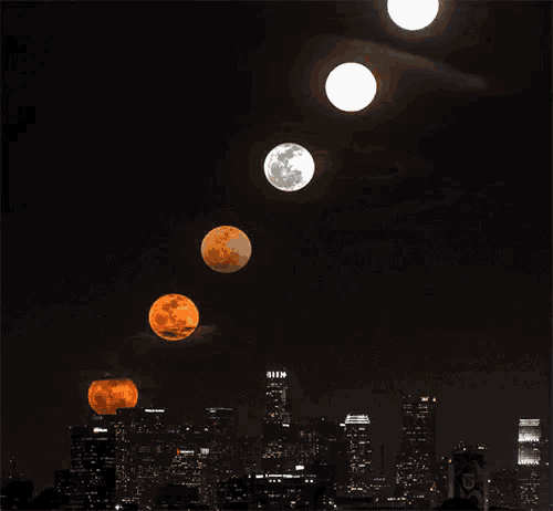 a city skyline at night with a full moon in the middle