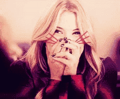a woman is covering her face with her hands and making a funny face
