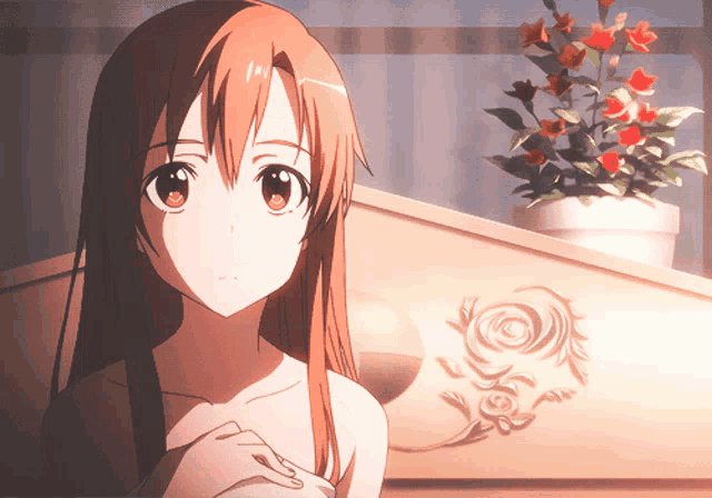 a girl with long brown hair is standing in front of a flower pot