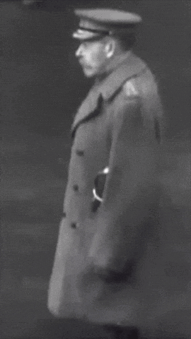a black and white photo of a man wearing a hat and coat