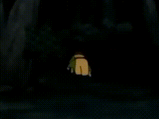 a cartoon character is standing in the dark with a light coming out of a window .
