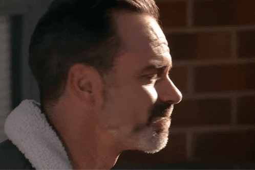 a close up of a man 's face with a white collar