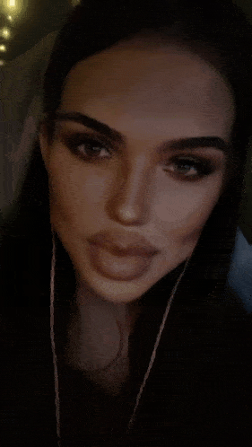 a close up of a woman 's face with earphones on