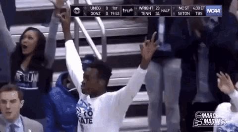a man is raising his arms in the air during a ncaa game
