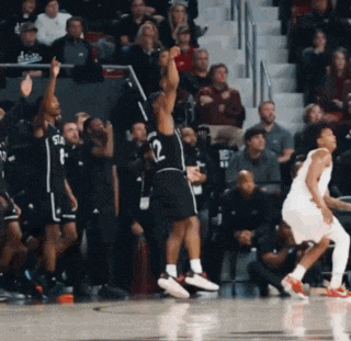 a basketball player with the number 12 on his jersey is jumping in the air