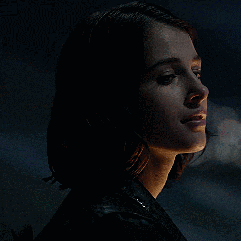 a close up of a woman 's face in the dark with a dark background