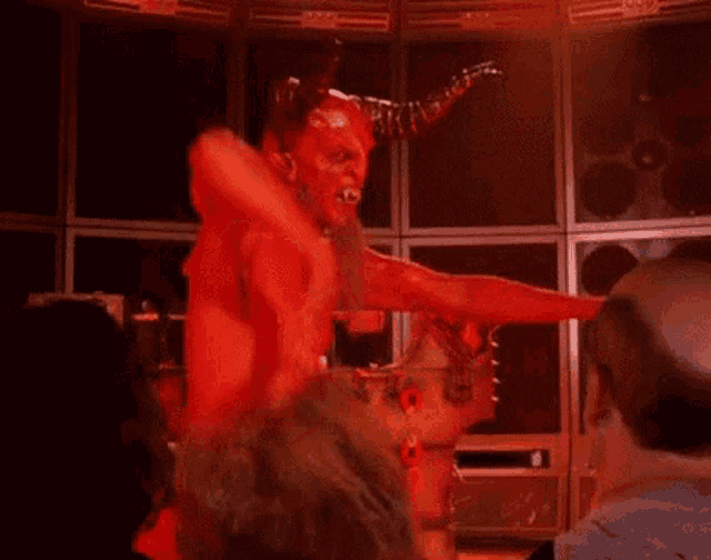 a devil with horns is standing in a room