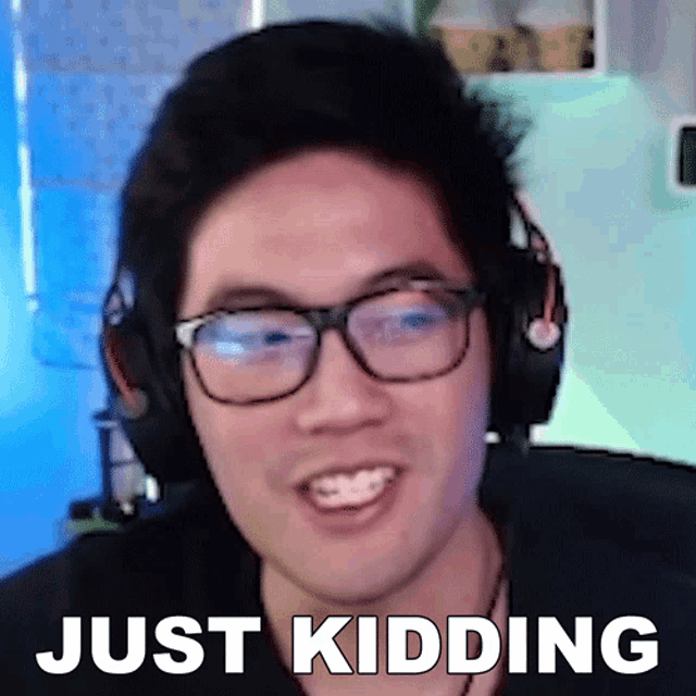 a man wearing glasses and headphones with the words just kidding behind him