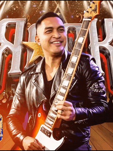 a man in a leather jacket is smiling while holding a guitar in front of a sign that says rock