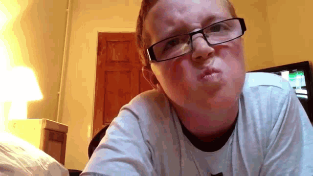a young man wearing glasses and a nike shirt makes a funny face