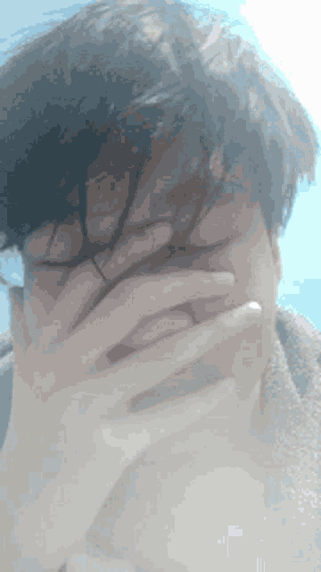 a person covering their face with their hand in a blurry photo