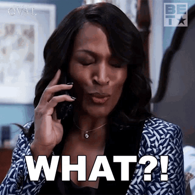 a woman is talking on a cell phone and says " what "