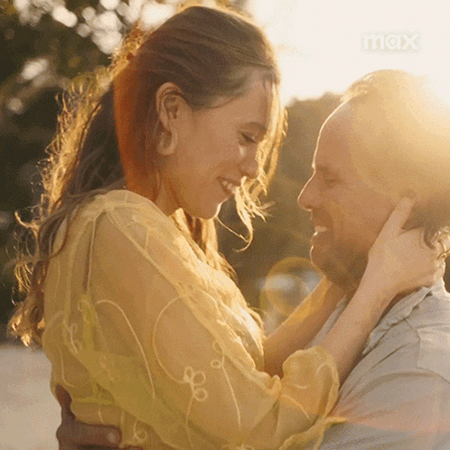 a man and a woman are looking into each others eyes .