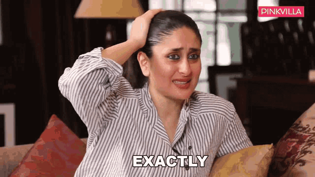 a woman is sitting on a couch with her hand on her head and the word exactly is visible