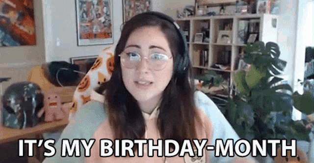 a young woman wearing headphones and glasses is sitting in a living room .