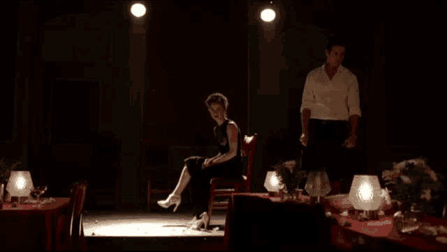 a woman wearing a pair of white high heels sits in a chair