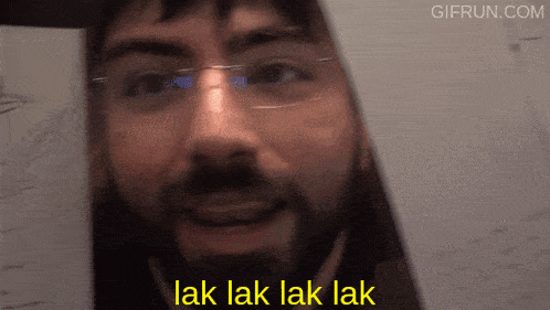 a man with glasses and a beard is smiling with the words " lak lak lak lak " below him