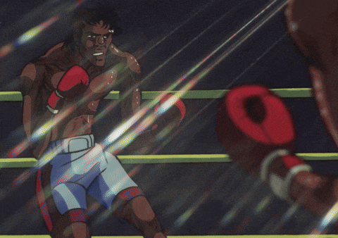 a shirtless boxer wearing red boxing gloves is sitting in a boxing ring