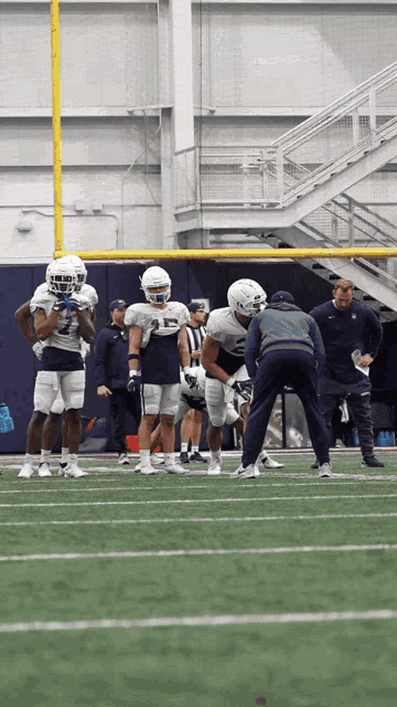 a group of football players are on a field and one has the number 5 on his jersey