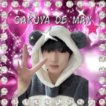 a man wearing a panda hat is giving a peace sign .