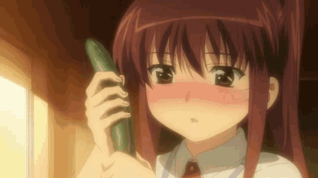 a girl with red hair is holding a cucumber in her right hand