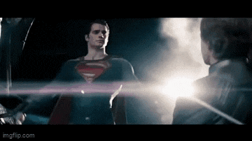 a man in a superman costume is standing next to a man in a black suit .