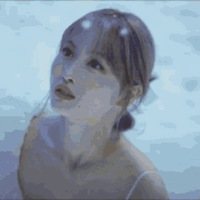 a close up of a woman 's face with a blue background