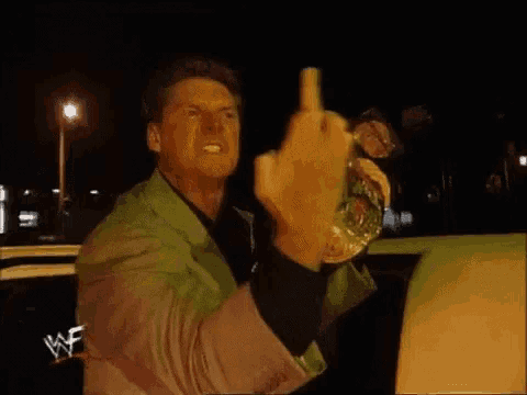 a man in a green suit is giving a middle finger