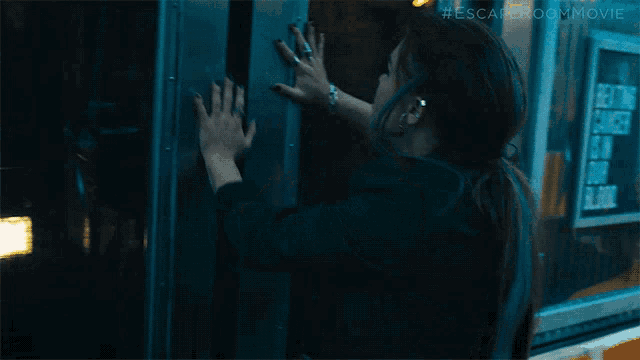 a woman 's hand is on a door that says escape room movie on the bottom