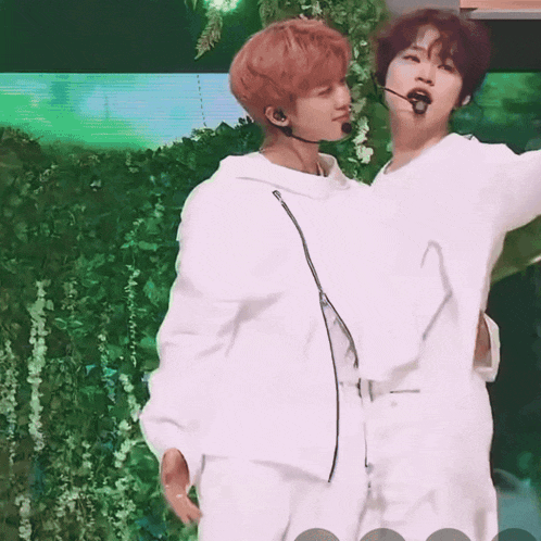 a couple of men standing next to each other with a green background