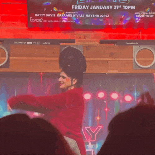 a woman in a red jacket is dancing in front of a sign that says ice