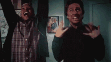 two men are celebrating with their arms in the air .