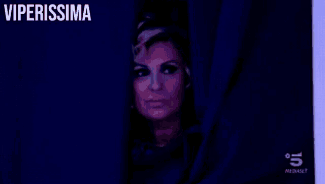 a woman peeking out from behind a blue curtain with the words viperissima written above her