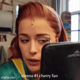 a woman with red hair is looking at herself in the mirror and says ' eleena # 1 cherry fan ' on the bottom