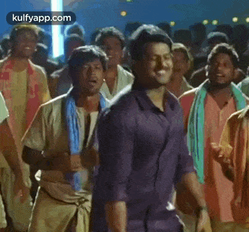 a group of men are standing in a crowd and dancing .