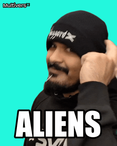 a man with a beard is wearing a beanie that says aliens