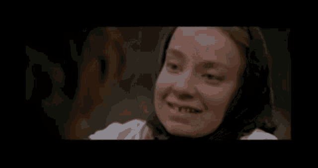 a woman with a scarf on her head is crying in a movie