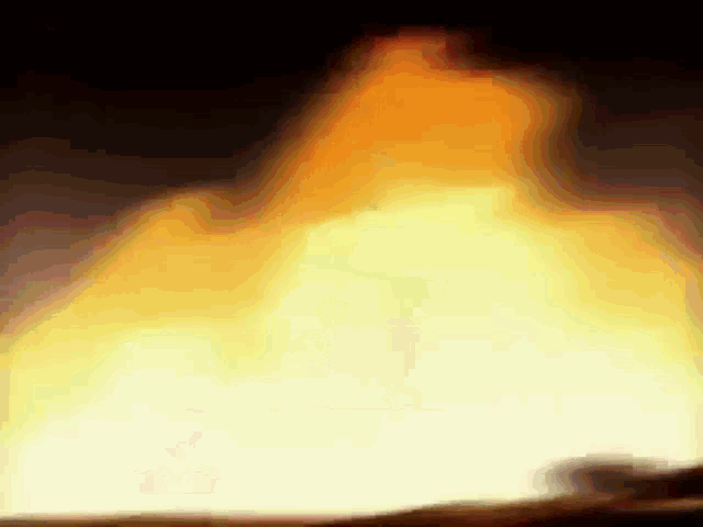 a close up of a fire in the dark with a lot of smoke coming out of it .