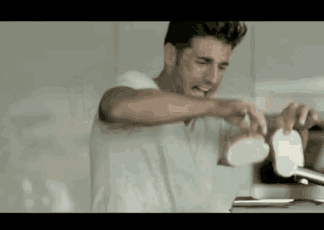 a man in a white shirt is toasting a piece of bread