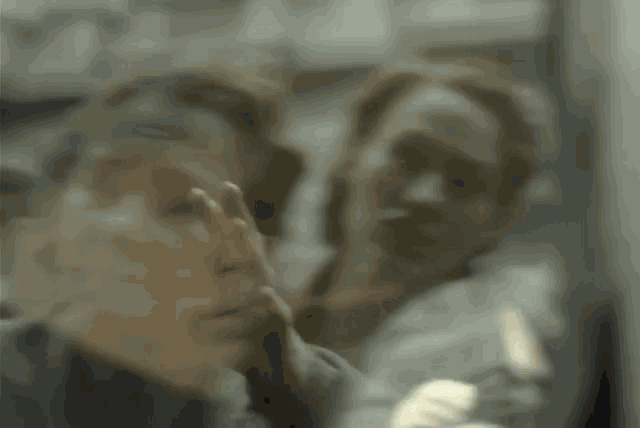 a blurry photo of a man holding another man 's neck .