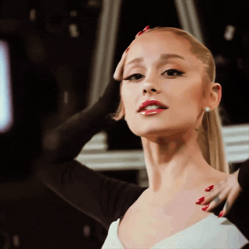 a woman with red nails holds her hand to her forehead
