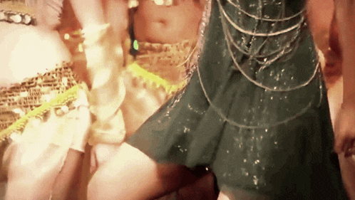 a woman in a green dress is dancing in a crowd