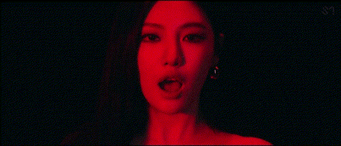 a close up of a woman 's face with a red light behind her .