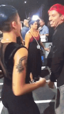 a man and a woman are dancing together in a crowd