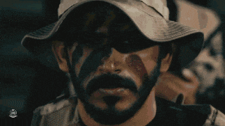 a man with a beard is wearing a hat with the word army on it