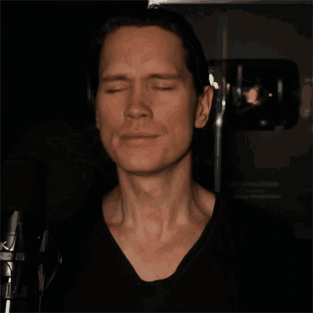 a man with his eyes closed in a black shirt