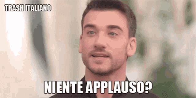 a man with a beard is saying niente applauso in italian