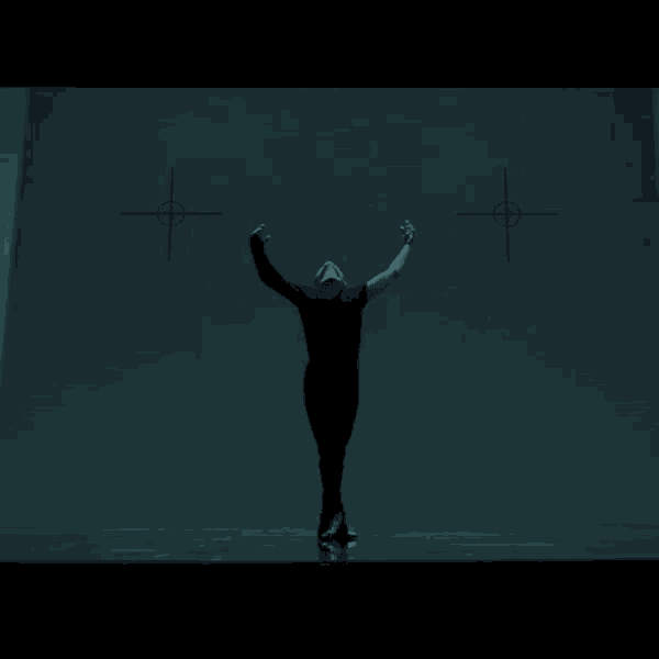 a man stands with his arms outstretched in front of two crosses on the wall