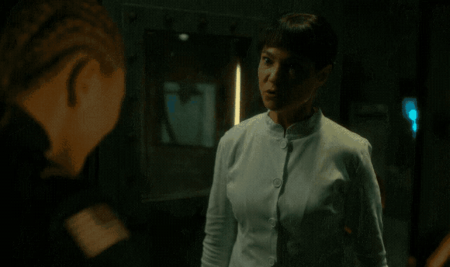a woman in a white shirt is talking to another woman and says you are an abomination