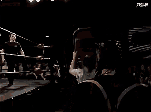 a man in a boxing ring is holding a sword in front of a crowd ..